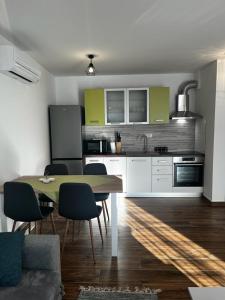 uma cozinha com mesa e cadeiras num quarto em Apartman Mila em Biograd na Moru