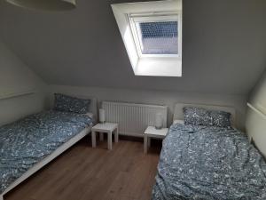 two beds in a small room with a window at Ferienwohnung Rosi in Schleswig