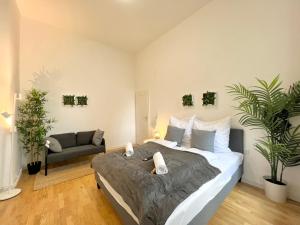 ein Schlafzimmer mit einem großen Bett und einem Sofa in der Unterkunft Jungle Retreat Apartments im Zentrum in Bremen