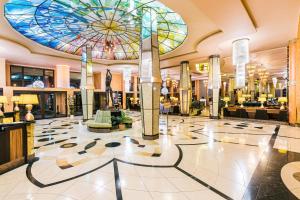 un grand hall avec un plafond en vitraux dans l'établissement Hotel Savannah, à Chvalovice