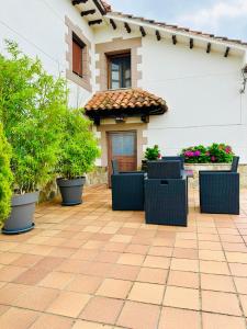 a patio with chairs and plants in front of a house at Apartamentos Nel I in Santillana del Mar