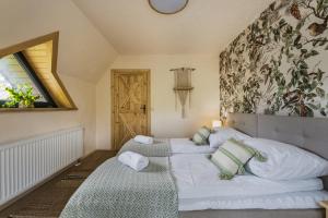 a bedroom with two beds with pillows and a window at Willa Skała in Kościelisko