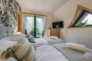 a group of four beds in a room with a window at Willa Skała in Kościelisko