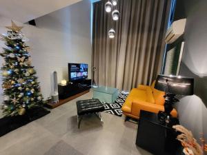 una sala de estar con un árbol de Navidad y un sofá en Empire Damansara Designer Soho Karaoke & Netflix, en Petaling Jaya