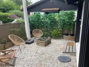 einen Garten mit Stühlen, einem Tisch und einer Stange in der Unterkunft Chambre d'HÔTE Maison De L'amitié in Lanton