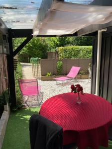 einen Tisch mit einer Blumenvase auf einer Terrasse in der Unterkunft Chambre d'HÔTE Maison De L'amitié in Lanton