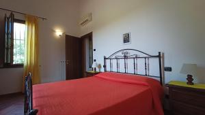 1 dormitorio con cama roja y manta roja en il Chiassetto Agriturismo No Kids, en Cascina