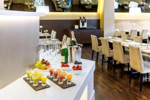 una mesa con bebidas y fruta en un restaurante en NH Collection Berlin Mitte am Checkpoint Charlie en Berlín