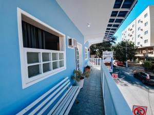 een blauw gebouw met een bank naast een straat bij Pousada Água Marinha in Cabo Frio