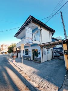 een wit gebouw aan de straatkant bij Pousada Água Marinha in Cabo Frio