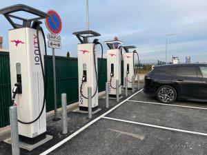 una fila di auto elettriche parcheggiate in un parcheggio di Holiday Inn Dijon Sud - Longvic, an IHG Hotel a Digione