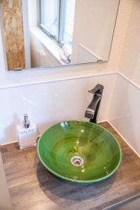 a green sink in a bathroom with a mirror at KIZUNA HOTEL Gojo Kiyomizu-dera Kamogawa in Kyoto