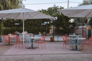 un groupe de tables et de chaises avec parasols dans l'établissement Sourediko, à Kambos