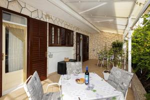 una mesa y sillas en un patio con una botella de vino en Balic Apartments - Hvar, en Hvar