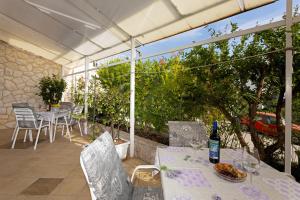 un patio con una mesa y una botella de vino en Balic Apartments - Hvar, en Hvar