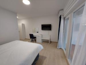 1 dormitorio con 1 cama, escritorio y TV en Guest House Nina, en Novigrad Istria