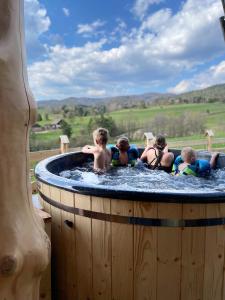 un grupo de niños jugando en una bañera de hidromasaje en Góralskie Domki na Podhalu - z jacuzzi, en Maniowy