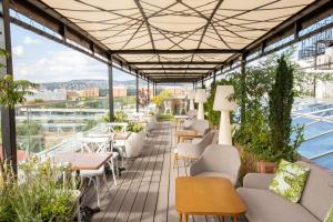 een balkon met stoelen en tafels en uitzicht op de stad bij Mystery Hotel Budapest in Boedapest