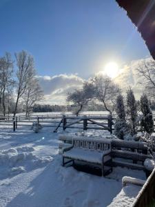 een bank bedekt met sneeuw naast een hek bij Steffens Hof in Worpswede