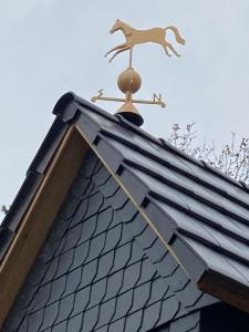 een windwijzer op het dak van een huis bij Steffens Hof in Worpswede