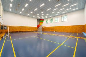 een fitnessruimte met een blauwe vloer en een volleybalveld bij Hotel Sepetná - Silvestr s polopenzí, animačním programem a silvestrovskou párty! in Ostravice