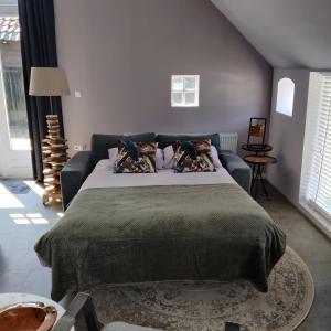 een slaapkamer met een groot bed en een bank bij B & B Diever in Diever