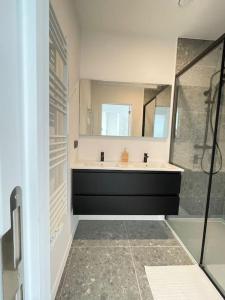 bagno con vasca, lavandino e specchio di #2800ourhome 301 a Mechelen