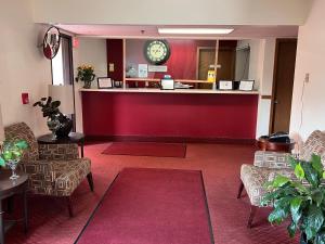 a hotel lobby with a reception counter and chairs at FairBridge Inn Express Chesterton in Chesterton