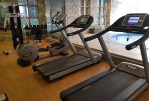 een fitnessruimte met diverse cardio-apparaten en een zwembad bij Casa Diora Hotel Jeddah in Jeddah