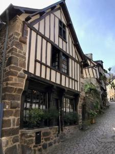 - un vieux bâtiment dans une rue pavée dans l'établissement Maison Médiévale, à Dinan