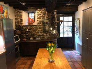 une cuisine avec une table et un vase de fleurs. dans l'établissement Maison Médiévale, à Dinan