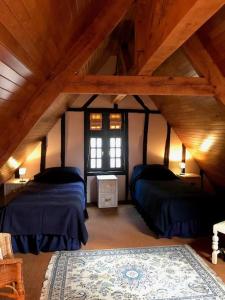 Cette chambre mansardée comprend 2 lits et une fenêtre. dans l'établissement Maison Médiévale, à Dinan