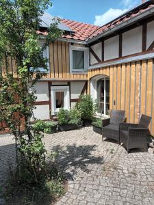 un patio con due sedie e una casa di Franks kleines Bauernhaus in Dresden a Dresda