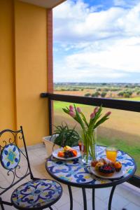 een tafel met 2 stoelen en borden eten op een balkon bij Hotel Residence Federiciano in Valenzano