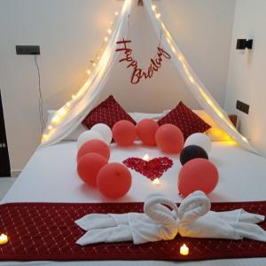 a bed with red and white decorations on it at ENOCEAN HOMESTAY in Cherai Beach