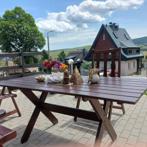 una mesa de picnic de madera en un patio con una casa en Apartments - Lehmanns Ferienwohnungen, en Kurort Oberwiesenthal