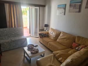 uma sala de estar com um sofá e uma mesa em Vilamoura Alecrim em Vilamoura