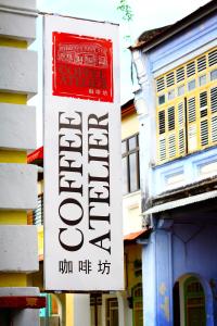 un cartello per un negozio sul lato di un edificio di Coffee Atelier a George Town