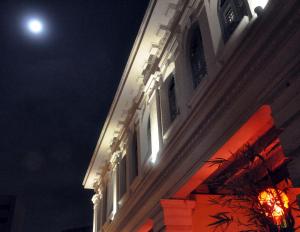 un edificio illuminato con una torre dell'orologio di notte di Coffee Atelier a George Town