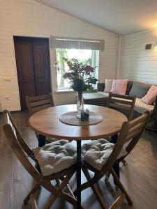 a dining room table with a vase of flowers on it at Vecliepas in Vārve