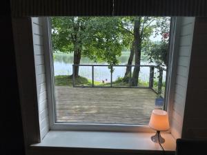 a window in a house with a view of a lake at Vecliepas in Vārve