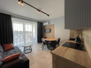 cocina y sala de estar con sofá y mesa en APT. 539, en Dziwnówek