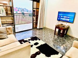 uma sala de estar com um sofá e uma televisão de ecrã plano em Trendy apartments em Entebbe