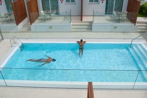 zwei Personen schwimmen in einem großen Pool in der Unterkunft MAR BIANCO - Gay Men Only in Maspalomas