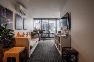 a living room with a couch and a tv at ‘Sunrise on Aura’ Apartment with stunning views. in Melbourne