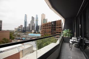 a balcony with chairs and a view of a city at ‘Sunrise on Aura’ Apartment with stunning views. in Melbourne