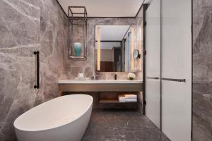 a bathroom with a white tub and a sink at Tianjin Marriott Hotel National Convention and Exhibition Center in Tianjin