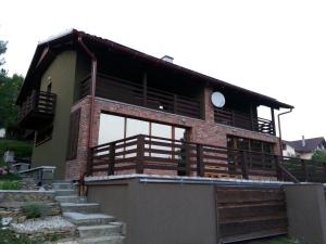 a house with a large balcony and stairs at Chata pri Vode in Kelča