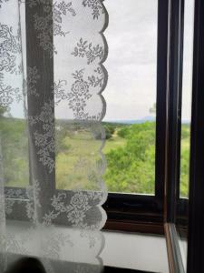 a window with a view of a green field at Vaki's country house in Pylos