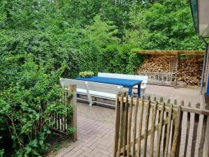 einen Picknicktisch in einem Garten neben einem Zaun in der Unterkunft Holiday home bos en heide in Otterlo